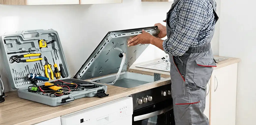 Handyman repairing a cooktop and checking wiring connections in Fort Worth, TX