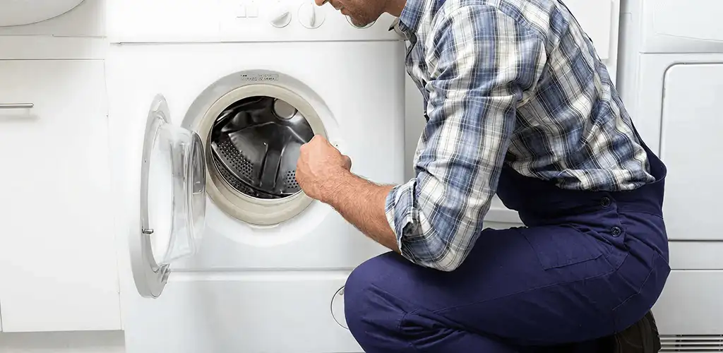 Handyman inspecting a dryer drum and internal parts for repair in Fort Worth, TX