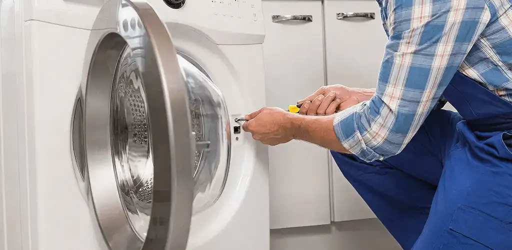 Handyman repairing a clothes dryer and checking electrical connections in Fort Worth, TX