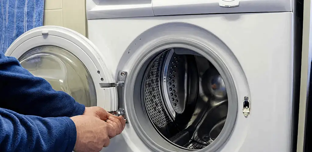 Washing machine repair handyman checking a front-load washer door and latch in Fort Worth, TX