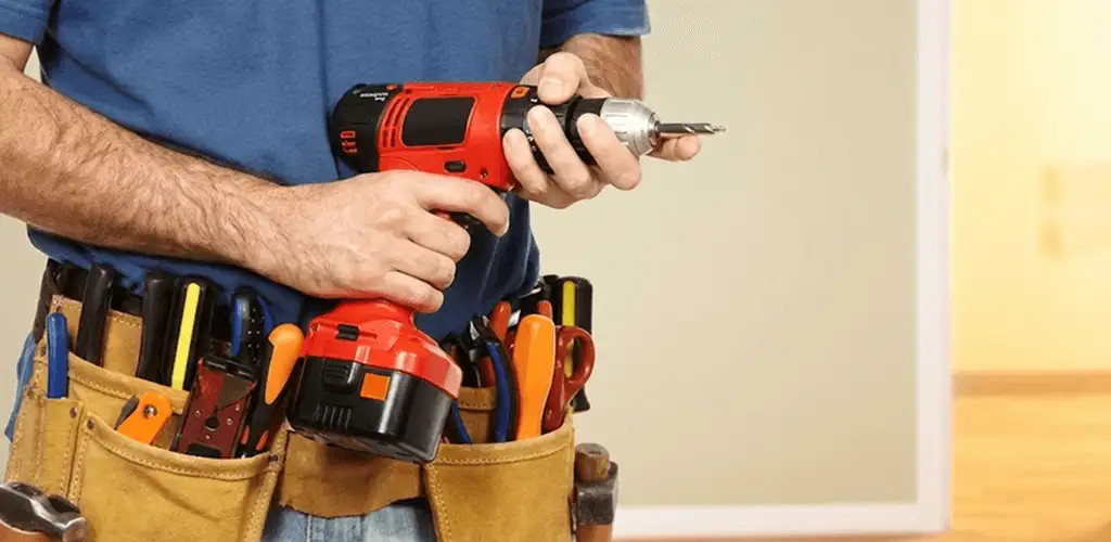 Handyman holding a power drill for home repairs and installations in Fort Worth, TX